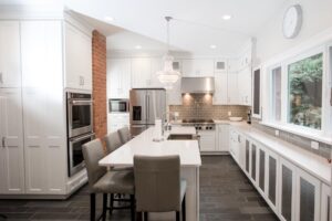 White shaker kitchen cabinets with farmhouse sink in large island