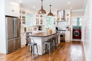 White kitchen cabinets with accent wood tone countertop on island
