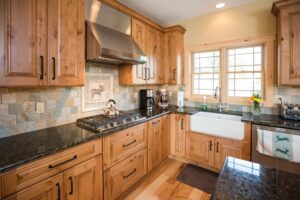 Natural wood tone kitchen cabinets with stainless steel range hood