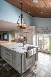 Gray washed cabinet island with farmhouse sink on end