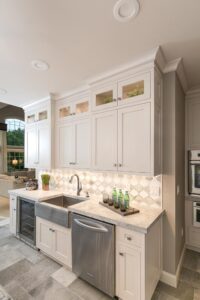 White inset cabinets with stainless steel farmhouse sink and appliances