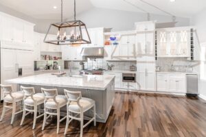 Large kitchen with white inset cabinets and gray island
