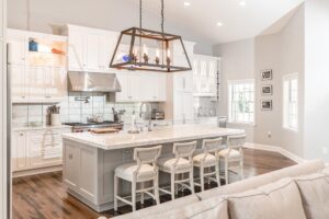 White cabinets with grey island and accent chandelier