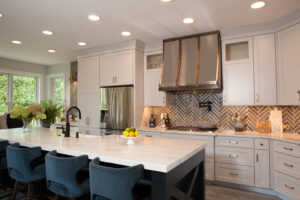 white inset kitchen cabinets with metal hood and white quartz countertop