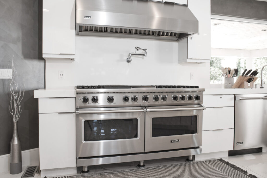 Large professional stainless steel dual stoves in white kitchen