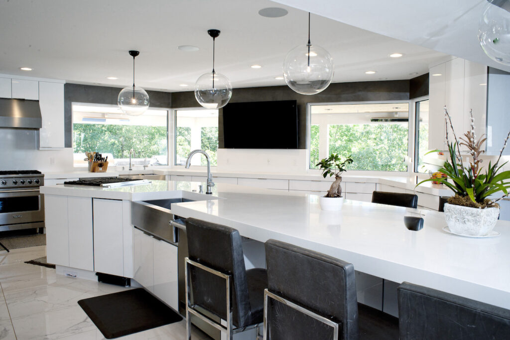 Long white kitchen island with farmhouse sink in island