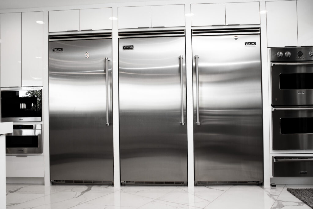 Kitchen with three stainless steel refrigerators