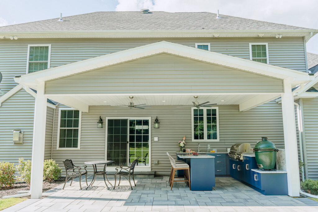 Outdoor kitchen with blue cabinets and dining space