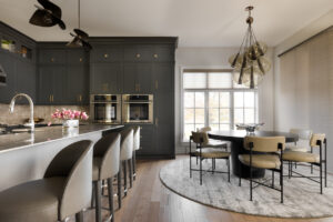 Dark grey kitchen cabinets with large island eat-in kitchen table space.