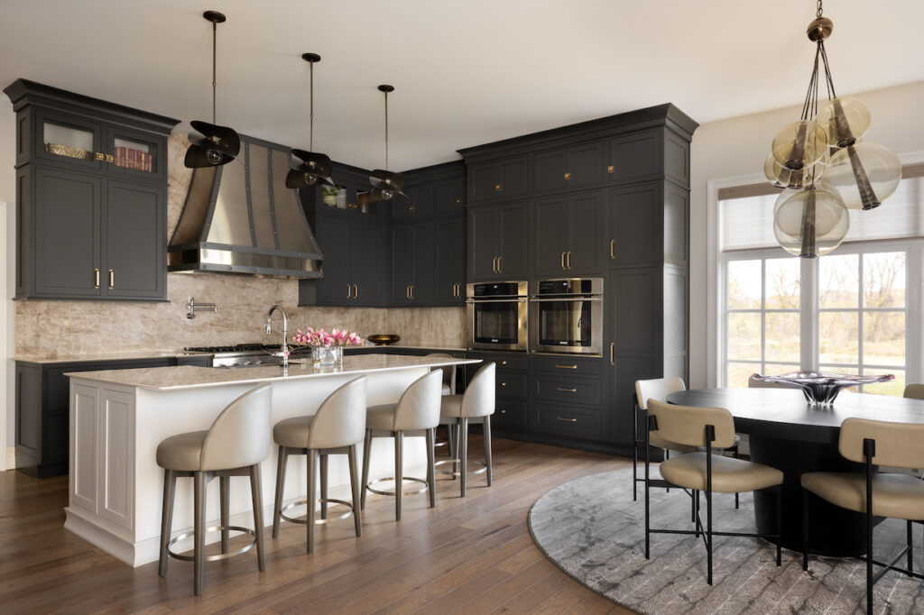 Large kitchen with dark grey cabinets, light grey island and eat-in kitchen table.