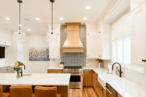 White upper cabinets with natural wood base cabinets and white countertop.