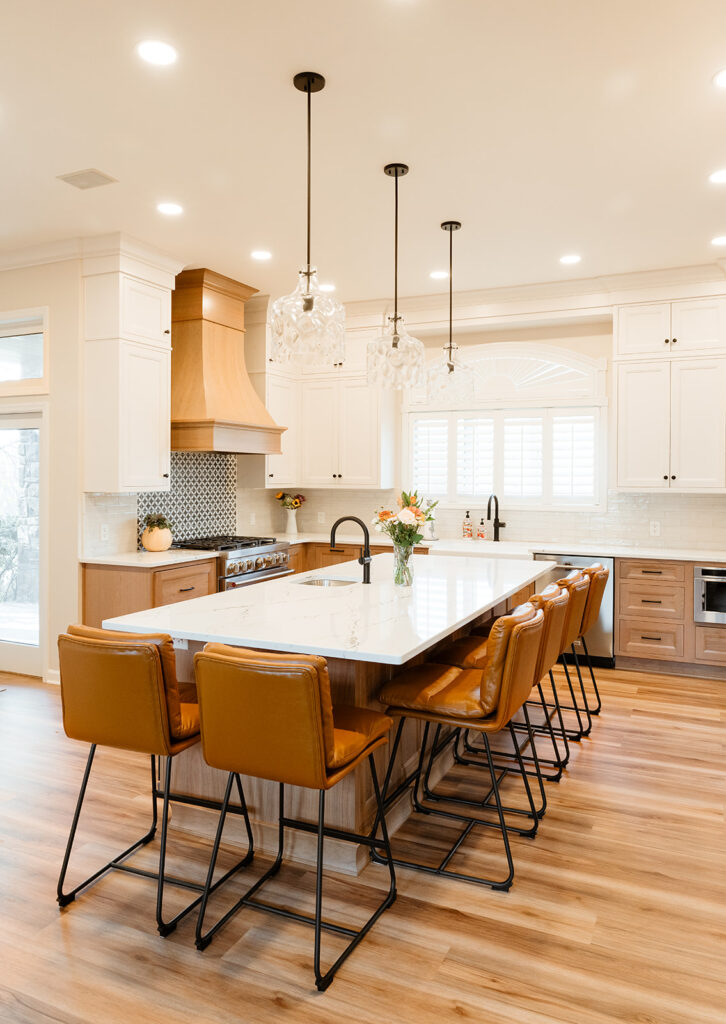 Large island paired with white upper cabinets with natural wood base cabinets