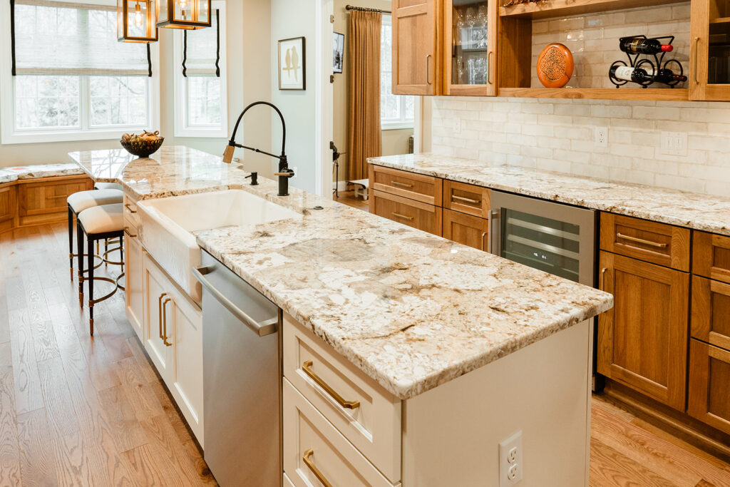 Marbled granite countertop on white island paired with oak cabinetry.