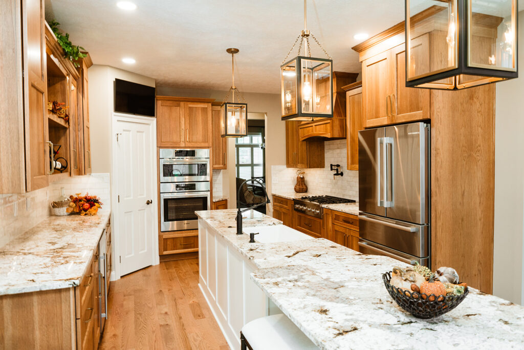 White long island with oak cabinets and stainless steel appliances