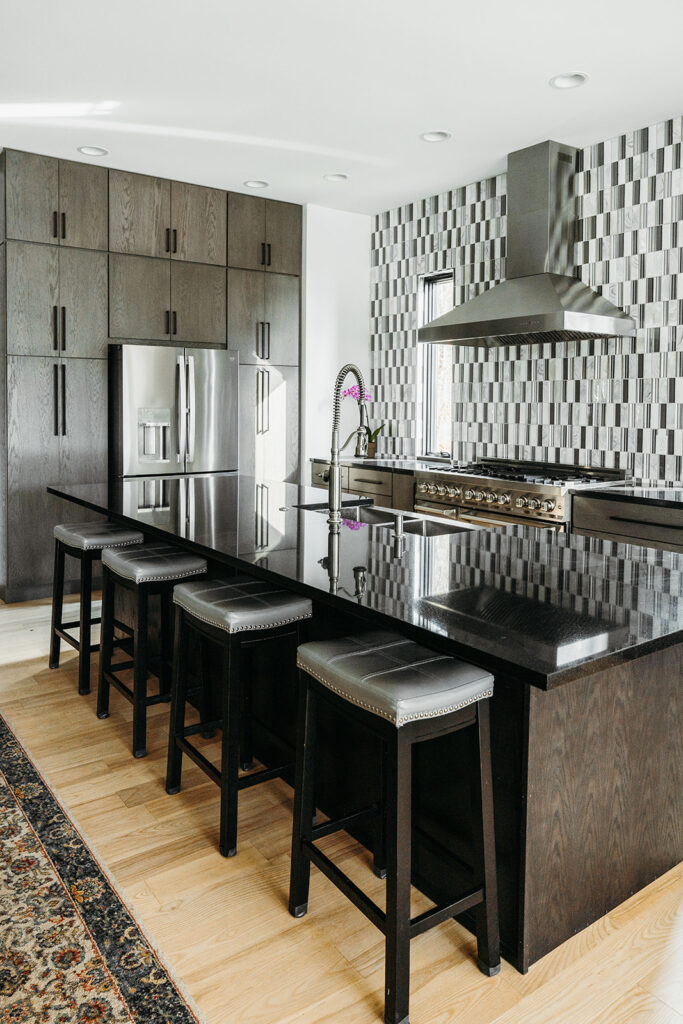 Large island with 4 stools and grey tone wood cabinets