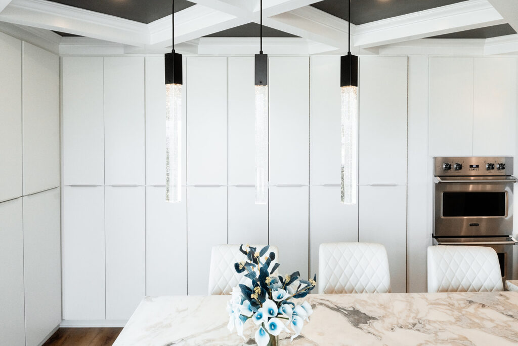 Floor to ceiling white cabinetry behind large center island